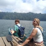 Family crossing Lake Tamblingan by traditional canoe after their jungle trekking adventure.