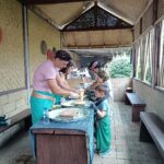 Guests learning traditional Balinese cooking methods with a local village host in Munduk